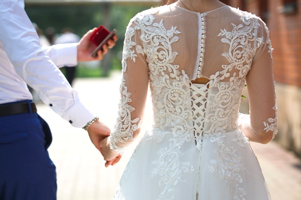 dos robe de mariee en dentelle tenant main mari